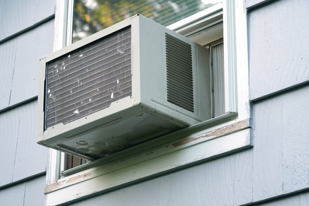 old air conditioner installed on house window