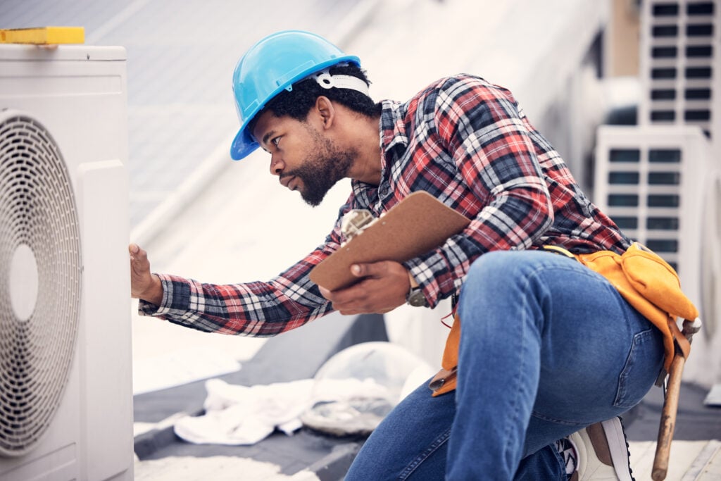 Technician, clipboard or air conditioning inspection on rooftop for safety, power or maintenance. Electrician, black man or paperwork on hvac system, ac repair or quality assurance for sustainability. hvac troubleshooting