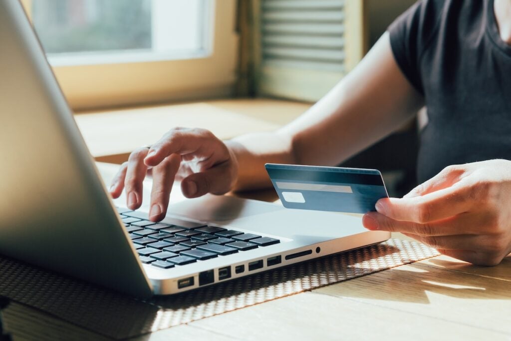 girl makes a purchase on the Internet on the computer with credit card best way to finance a new hvac system