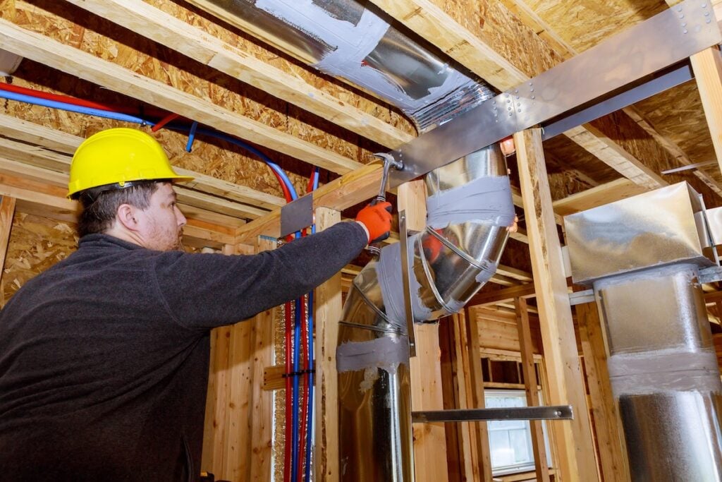 ductwork insulation Workers making final air duct conditioning HVAC system ventilation pipes stands for heating