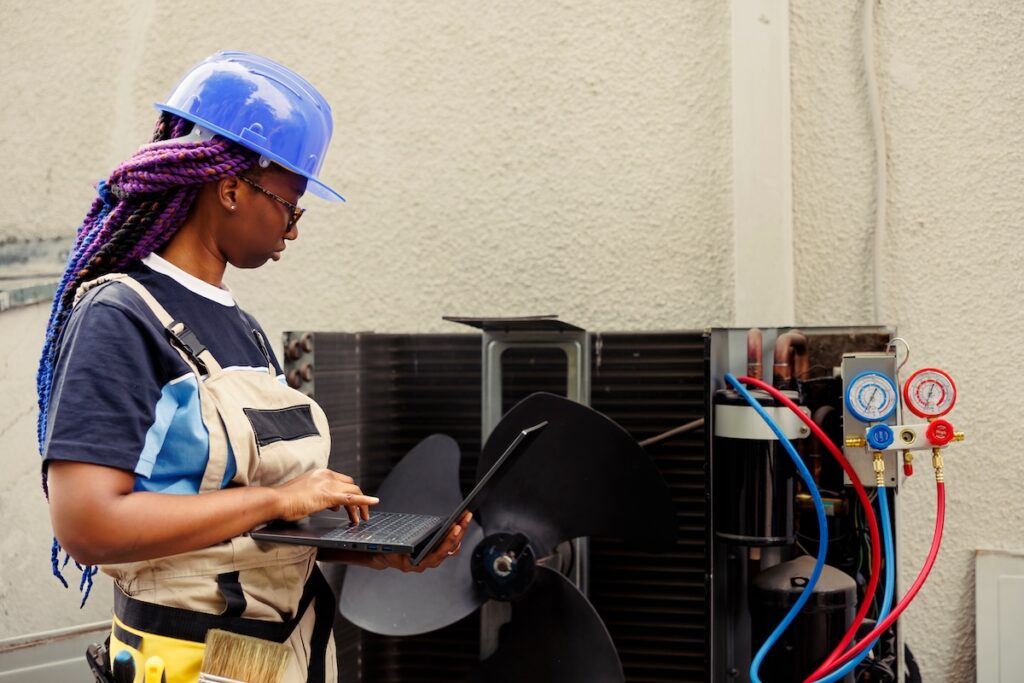 hvac inspection Licensed efficient electrician commissioned for leaks checking, making sure all hvac system vents are clear of waste. Precise serviceman doing air conditioner inspection, imputing data on laptop