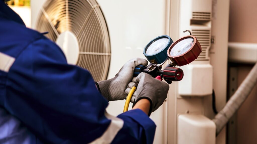 commercial hvac installation system service technician using measuring manifold gauge checking refrigerant and filling industrial air conditioner after duct cleaning maintenance outdoor compressor