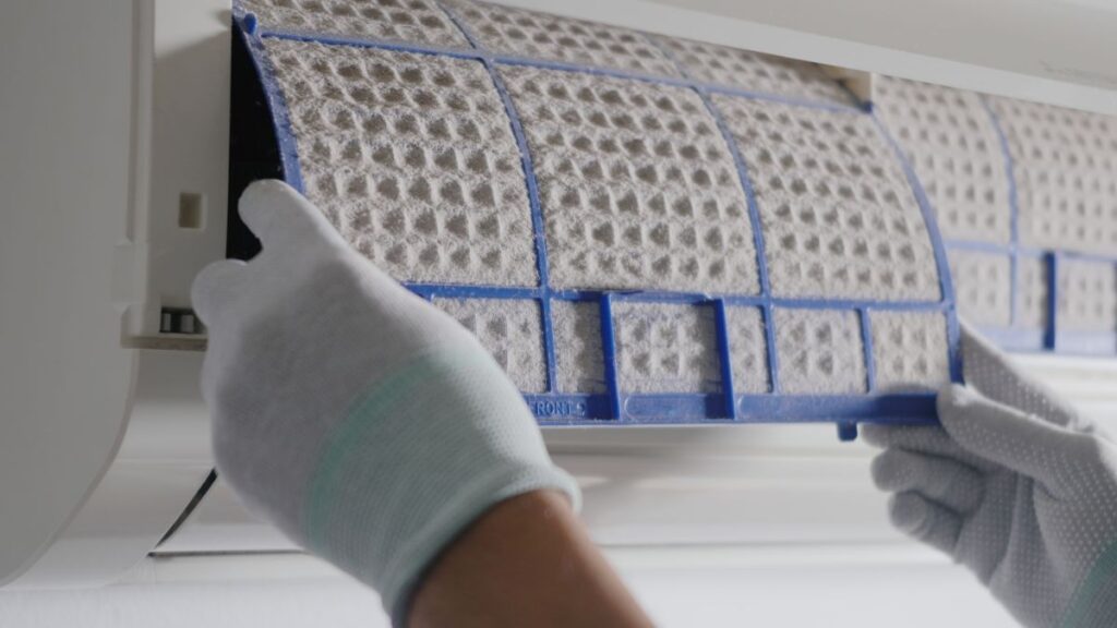 furnace cleaning two hands of technician man working pulling dusty filter in a big room at home