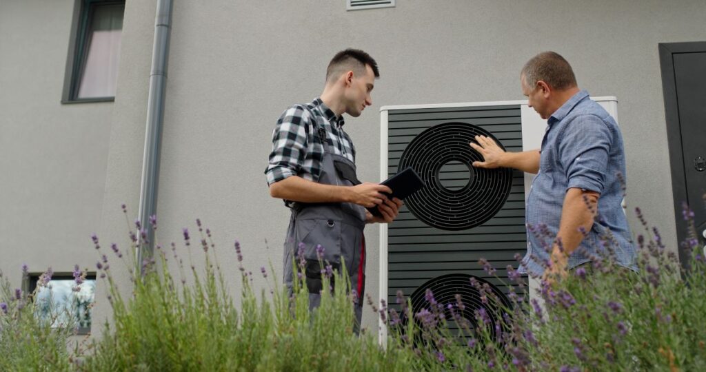 geothermal heat pump repair homeowner talking with worker hvac technician outside modern house