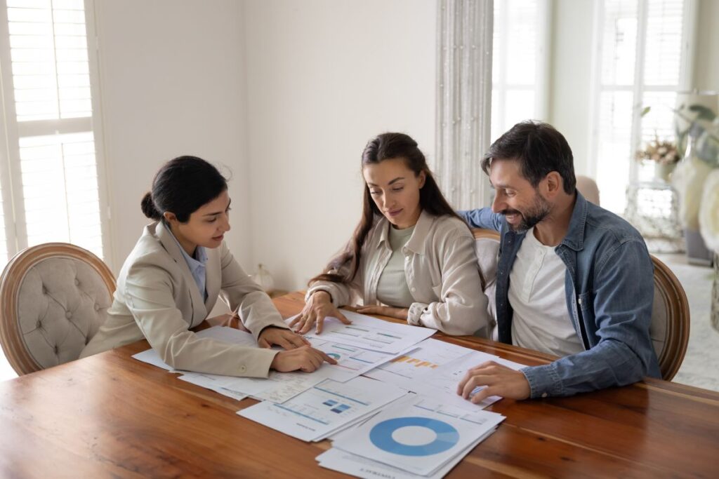 heat pump installation concentrated family listening to expert explaining financial review papers over the top of wooden table inside home