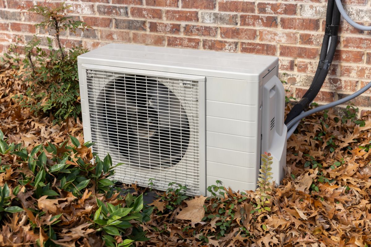 Air conditioning unit surrounded by fall leaves