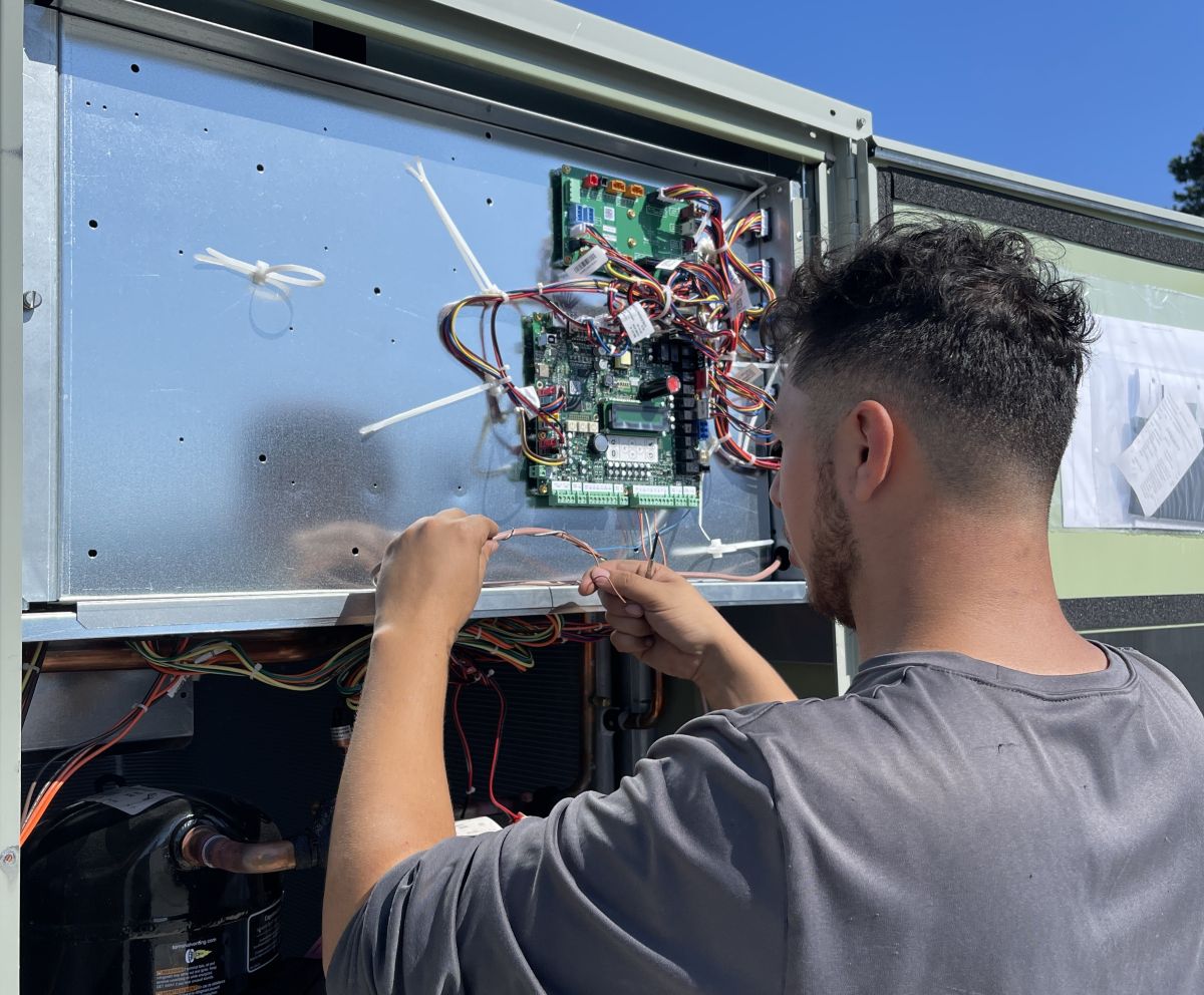 Panther HVAC team member maintaining an AC unit