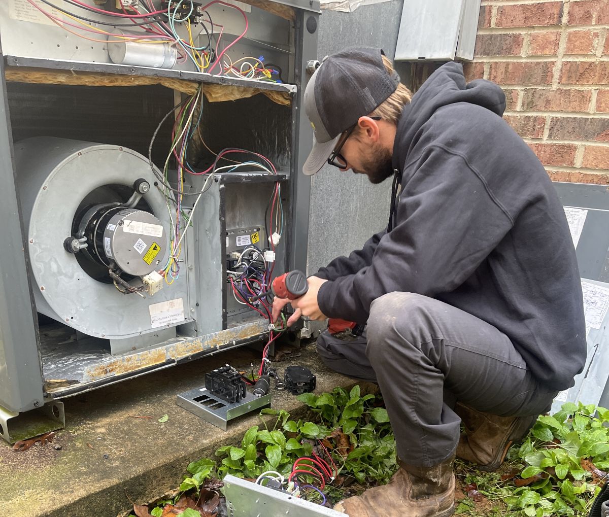 Panther HVAC team member working and maintaining an AC unit