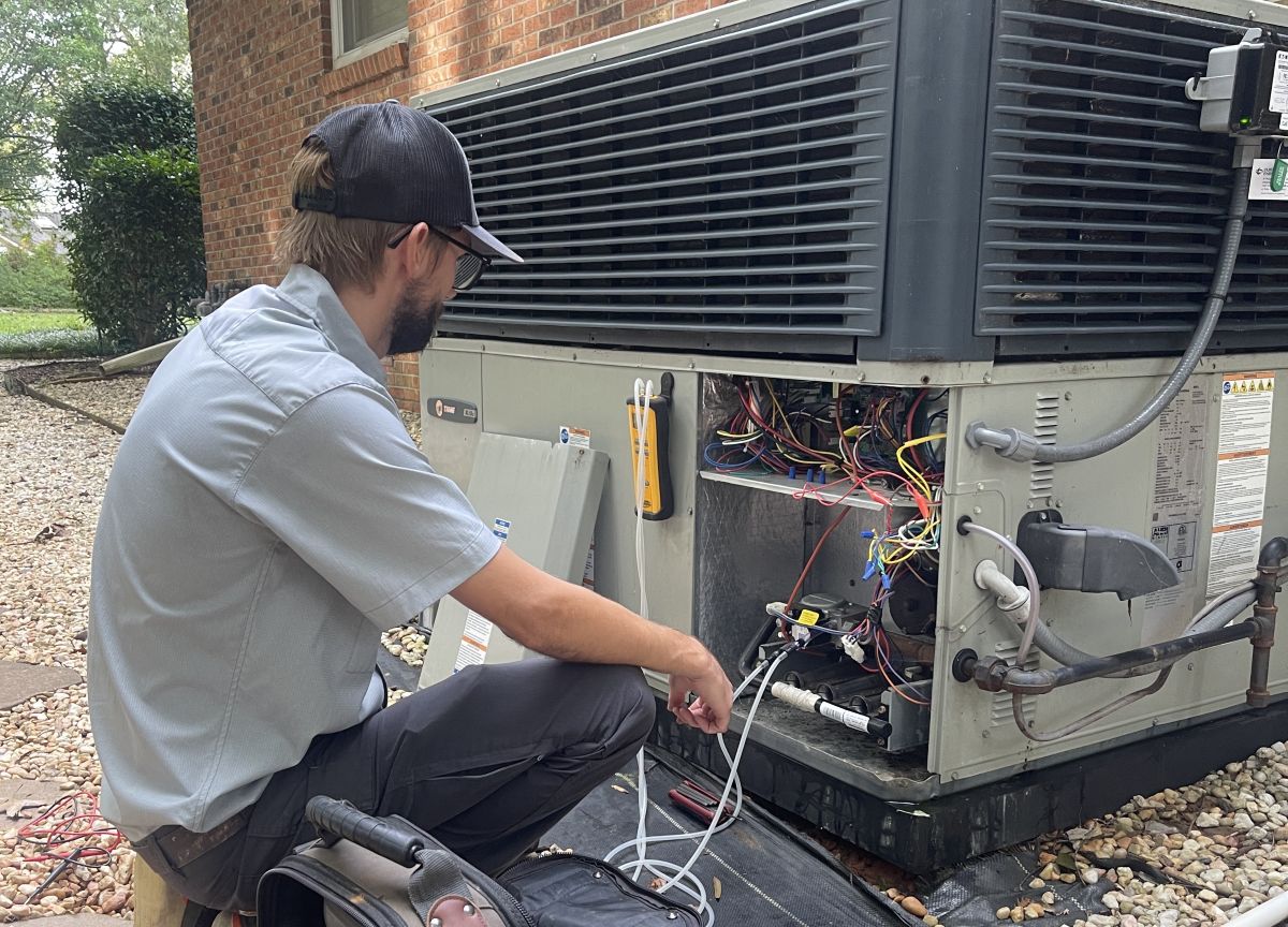 Panther HVAC team member maintaining a large AC unit