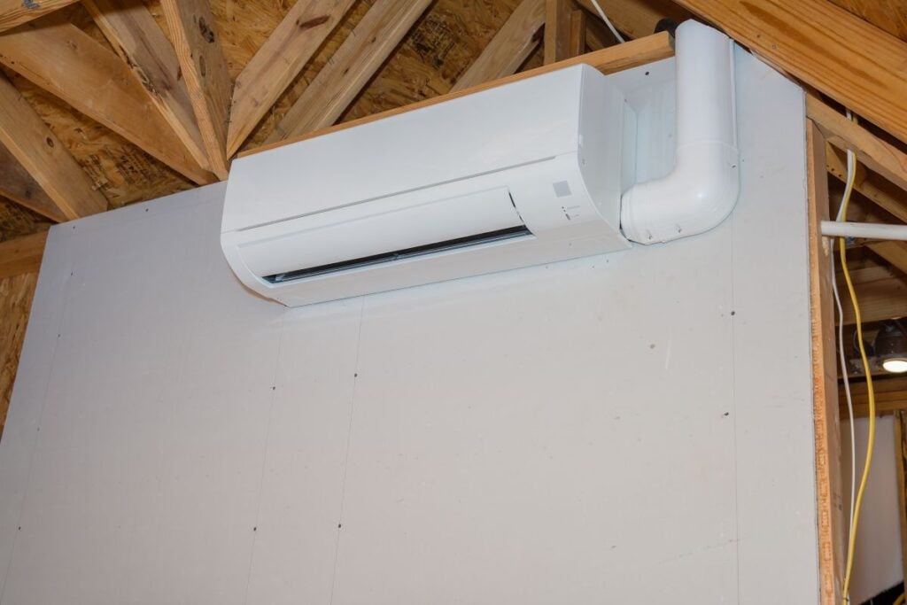 Mini-split ductless air conditioning unit installed in unfinished room
