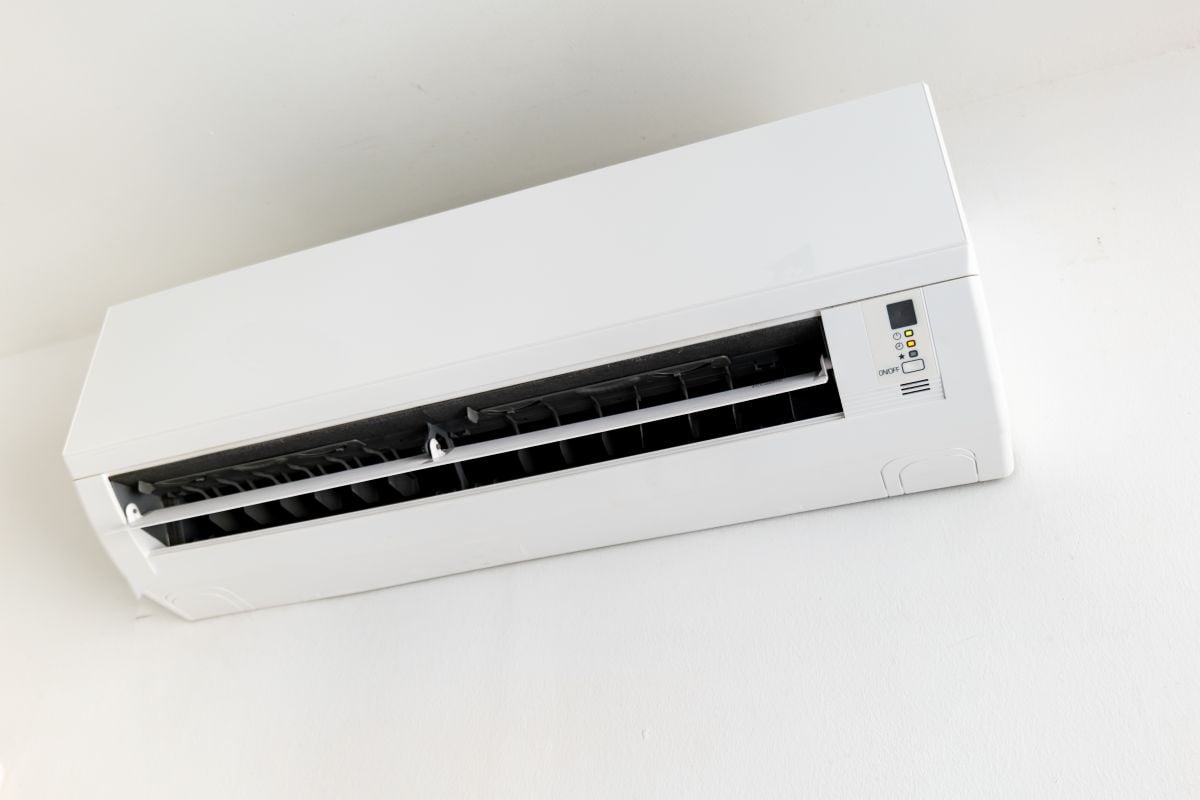 Wall-mounted split air conditioner unit on white wall, indoor climate control.