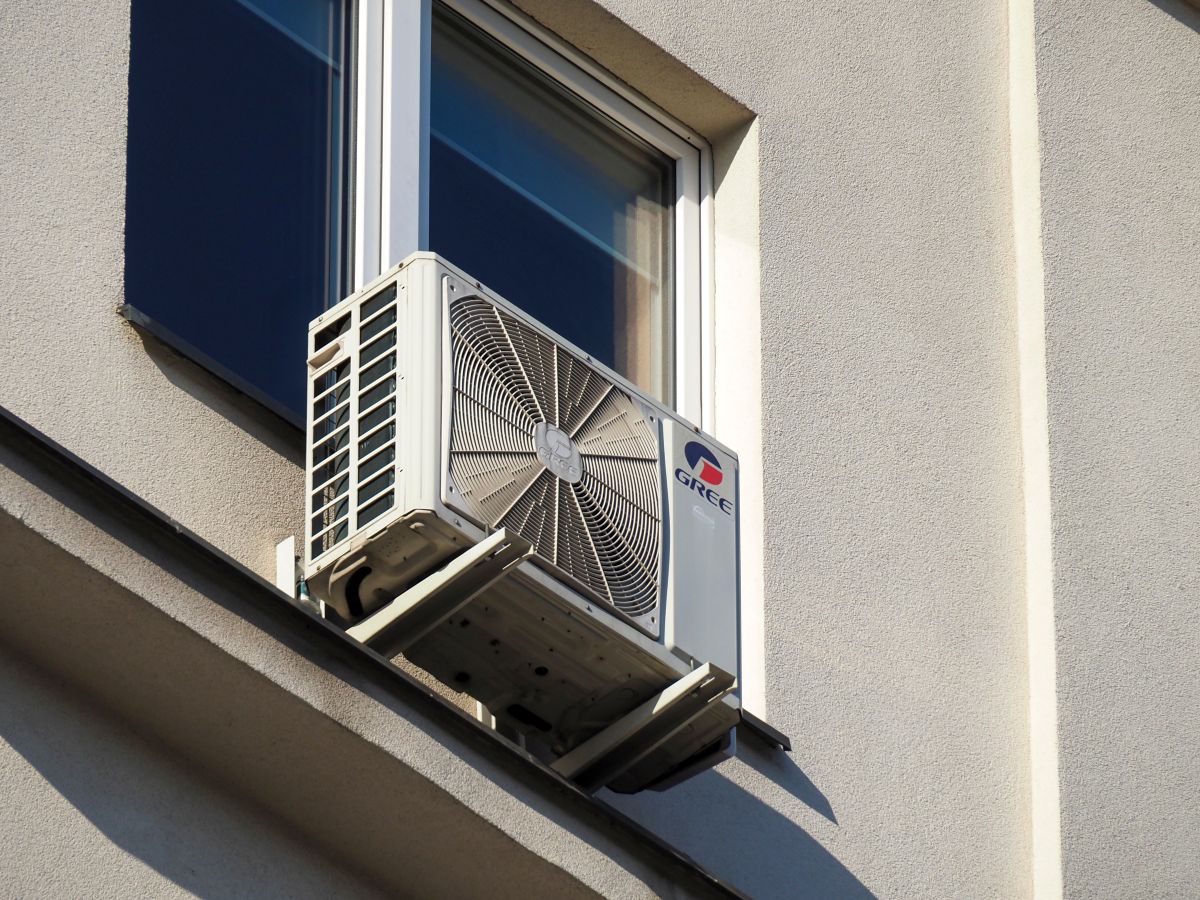 air conditioner outdoor unit mounted near a window on a modern building