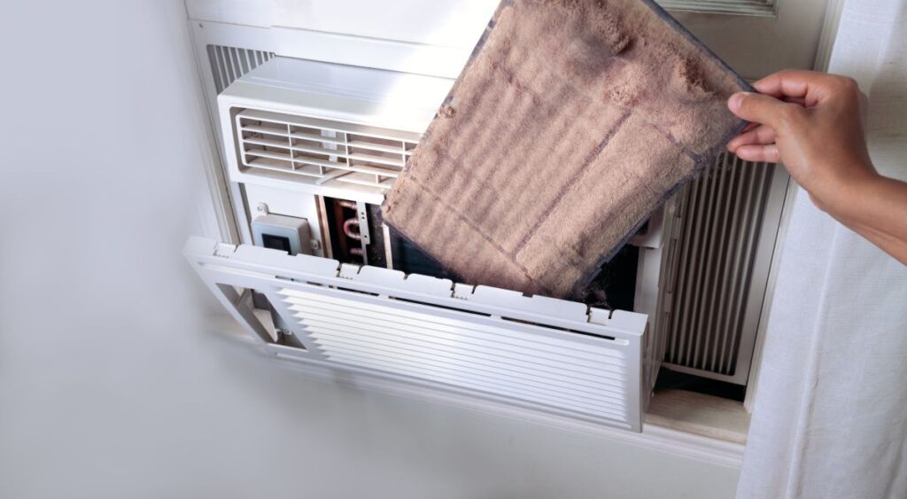 woman's Hand holding the dirty air conditioner home window filter