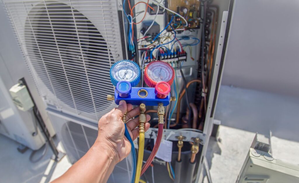 Air conditioning, HVAC service technician using gauges to check refrigerant and add refrigerant.
