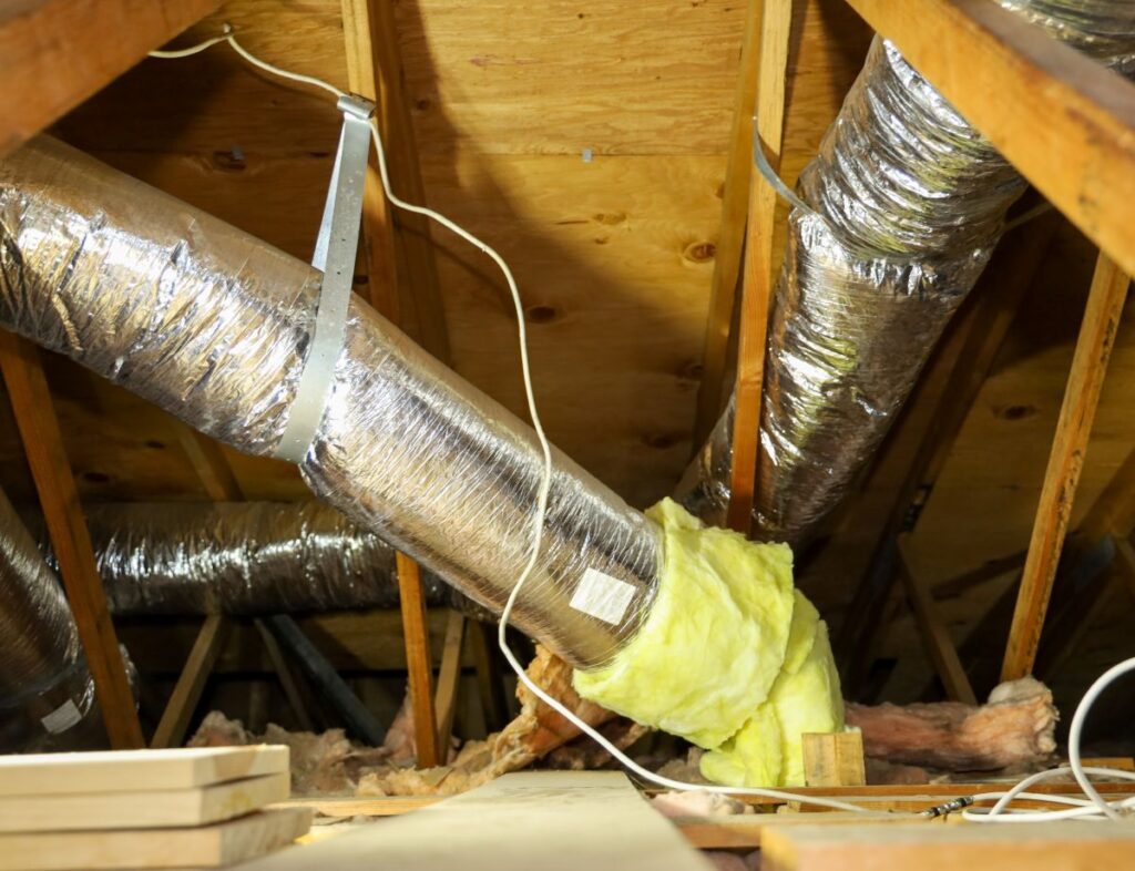View of fiber glass duct for central air in an attic.
